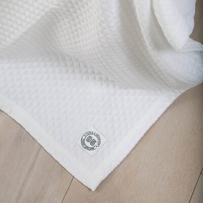 houten vloer met witte luxe bedsprei