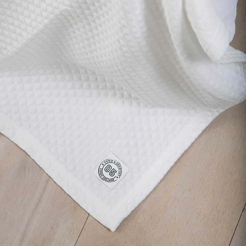 houten vloer met witte luxe bedsprei