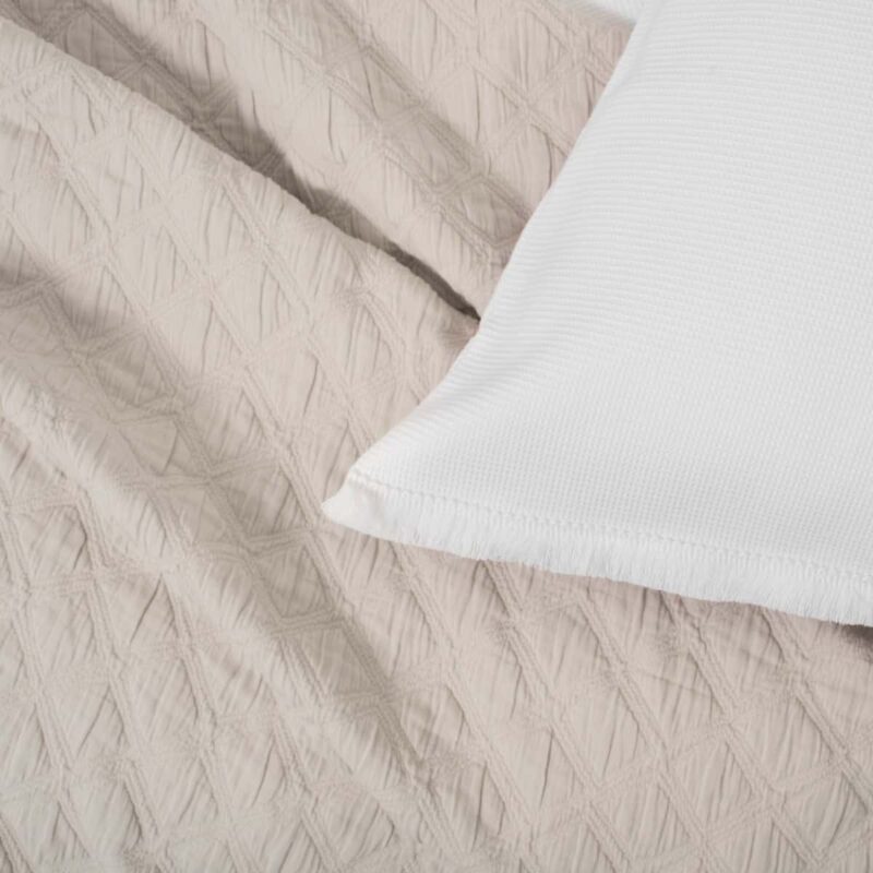 stuk van witte kussensloop en beige deken