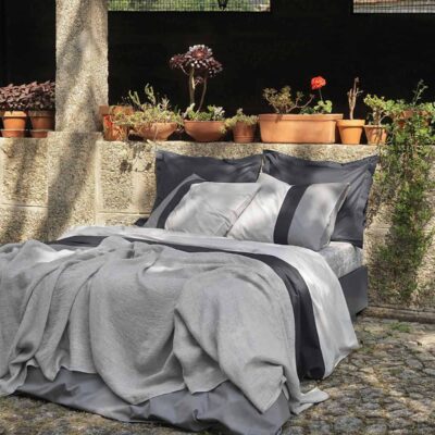 bed buiten mooi opgemaakt met een grijs percal katoen dekbedovertrek