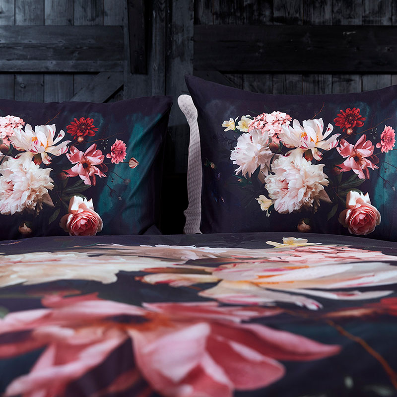 bed met donkere kleuren en frisse bloemen
