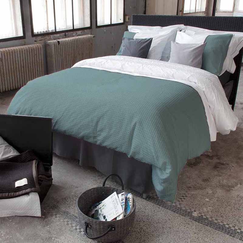 industriële slaapkamer met opgemaakt bed en wafelkatoen mintgroen/ wit dekbedovertrek