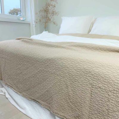 bed met sprei in zandkleur