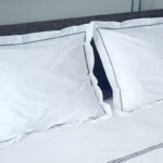 bed met 2 kussens en witte bovenlakens van katoen