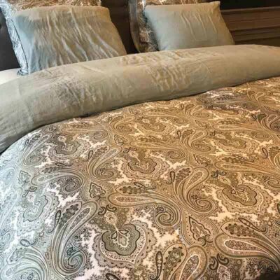 bed met 2 kussens en beige lakens met print