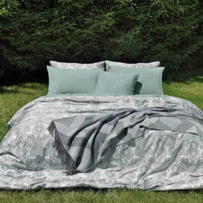 gras met bed opgemaakt met luxe lakensets