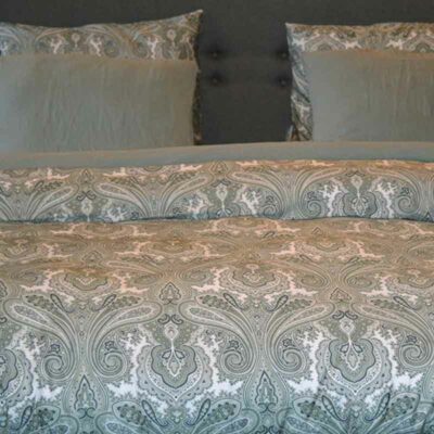 bed van voorkant opgedekt met lakens met print in groentinten