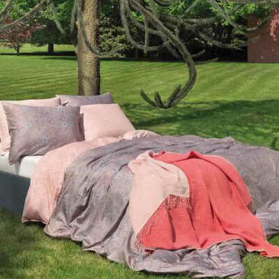 bed op gras met luxe lakens en bedspreien opgemaakt