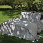 bed in tuin met grijze lakensets