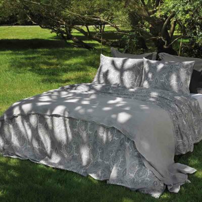 bed in tuin met grijze lakensets