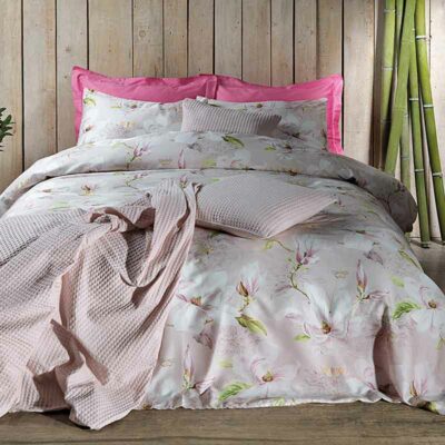 bed met roze wafelsprei en satijnen lakens