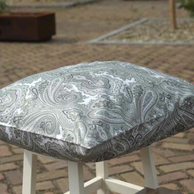 paisley spargroen hoofdkussen op witte kruk buiten