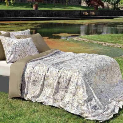 bed op gras met bovenlaken en kussens