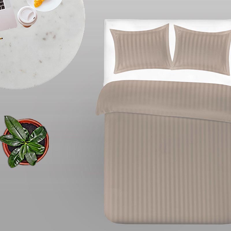 bed van bovenuit met twee kussens en gestreept taupe satijn dekbedovertrek