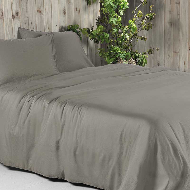 houten wand, plant en taupe dekbedovertrek