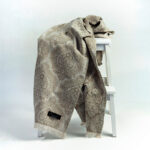 plaid in beige over een witte kruk
