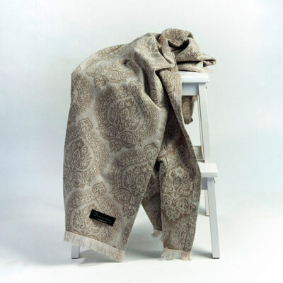 plaid in beige over een witte kruk