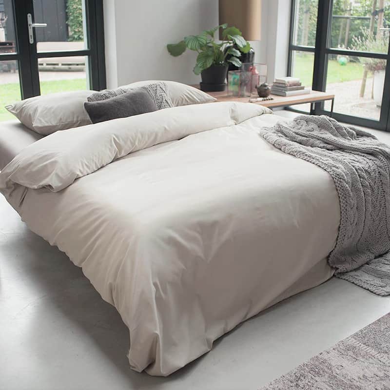 slaapkamer met grijze plaid en wit dekbedovertrek