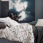 bed met wit dekbedovertrek met veertjes dessin