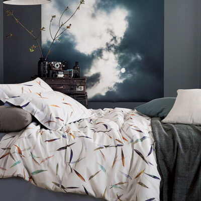 bed met wit dekbedovertrek met veertjes dessin