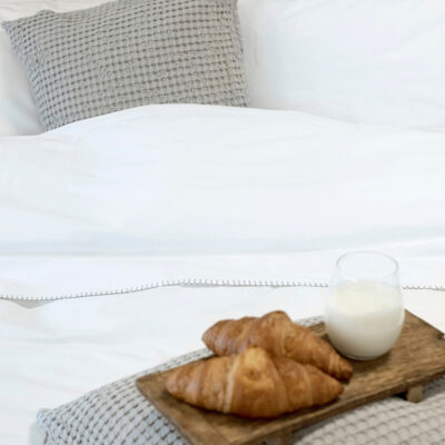 wit dekbed met croissants en drankje
