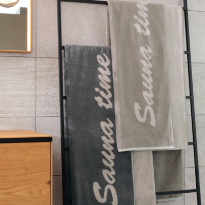 saunalaken in kleur steen en antraciet hangend over een handdoek ladder