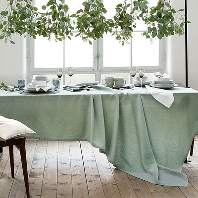 luxe tafellinnen op tafel met stoeltje, houten vloer en planten
