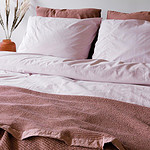 bed met roze dekbedovertrek en katoenen bedsprei