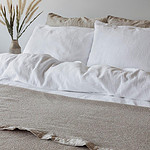 beige katoenen bedsprei met wit dekbedovertrek