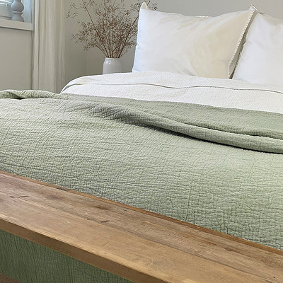bedsprei groen en houten voetbank