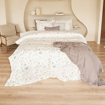 slaapkamer met bed en bloemen dekbedovertrek