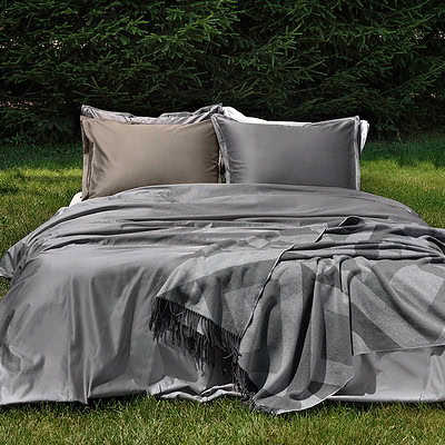 bed op gras met luxe dekbedovertrek